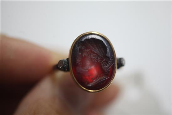 A Georgian yellow metal and oval red intaglio foil backed? ring with old cut diamond set shoulders, size L.